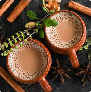 Organic black tea K-Cup pods with loose black tea leaves and fresh green tea leaves